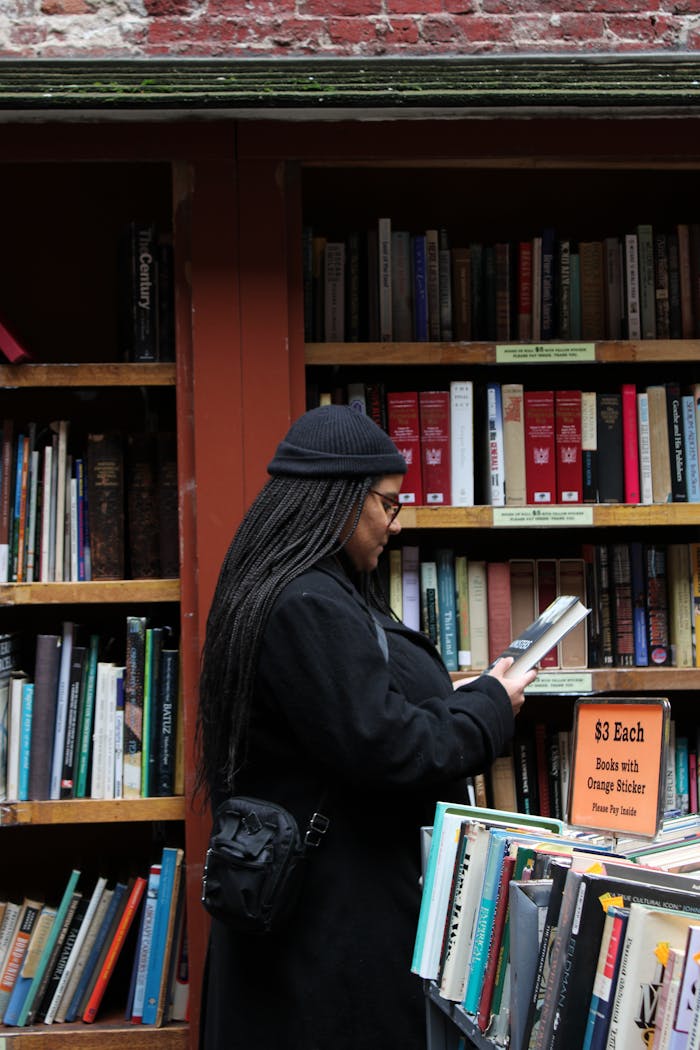 hero-img-01 A woman reading a book at an outdoor bookstore in Boston, Massachusetts.